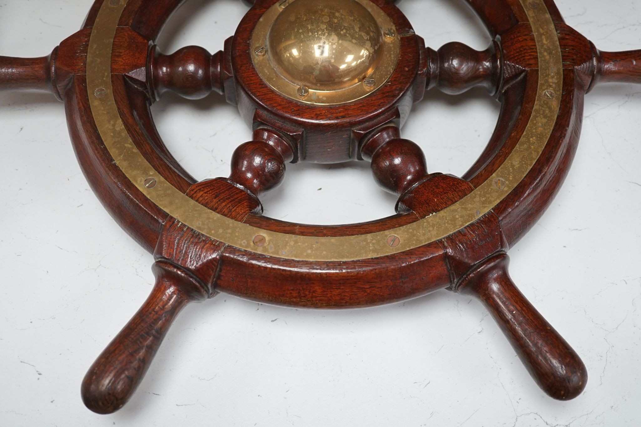 An early 20th century teak and brass mounted ship’s wheel 64cm